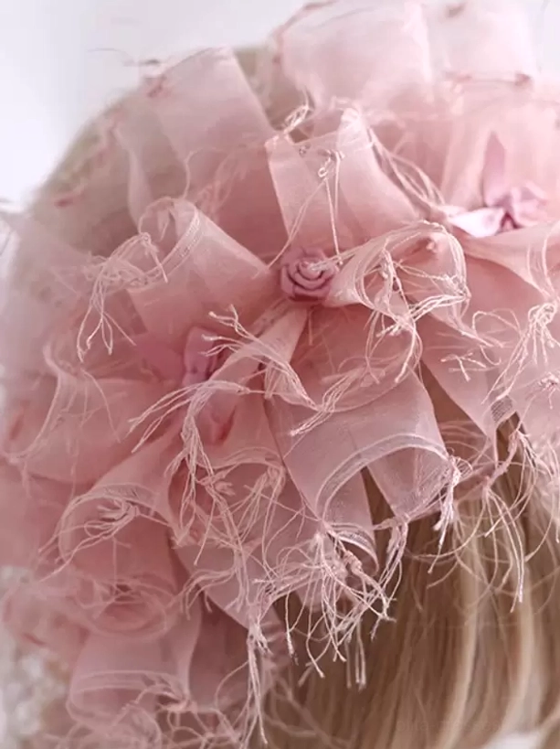 Close-up top view of pink sweet lolita headdress showing intricate sheer organza bows, tiny rose embellishments, and detailed frayed tulle texture craftsmanship