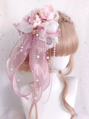 Delicate pink lolita hair accessory with pearl chains and artificial flowers, worn on mannequin with light brown wig, showcasing romantic Victorian-inspired design perfect for sweet lolita fashion and tea party occasions