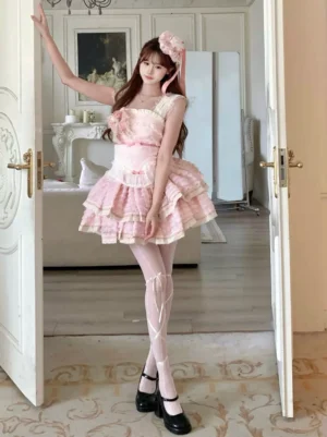 Pink sleeveless lolita dress side-front full body view with square neckline ribbon-trimmed stockings and block heel shoes showcase tiered ruffles