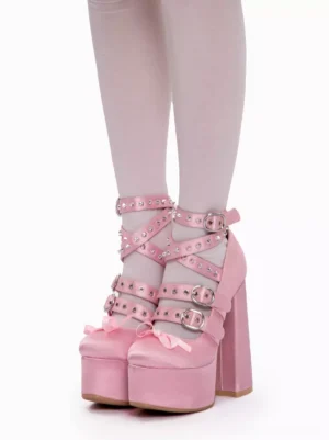 Pink lolita platform high heels direct front view showing cross riveted ankle straps and metal buckles on solid pink satin upper with white stockings
