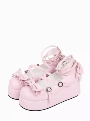 Pink Lolita platform pumps front three-quarter view showcasing baby pink PU leather with dual decorative bows and cross ankle straps with metal buckle fasteners on white background