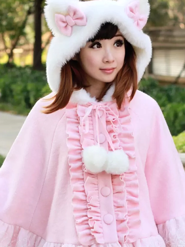 Close-up front detail of pink sweet lolita poncho coat featuring dual fluffy pom-pom accents and round front buttons with lace embellishments