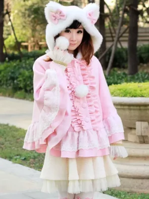 Sweet lolita pink poncho coat three-quarter front angle worn by model holding fluffy pom-pom accessory, featuring buttoned front placket and elegant draping