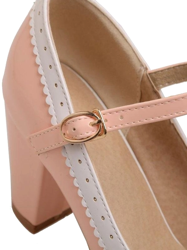 Lateral close-up detail of pink lolita pump showing ankle buckle strap perforated scalloped edge trim and chunky block heel structure on white background