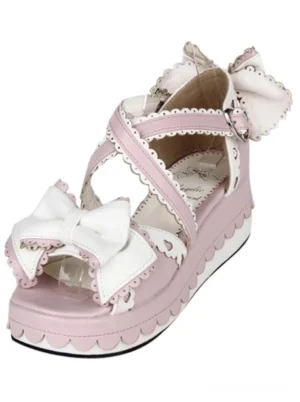 Single pink lolita platform sandal displayed in side-front three-quarter angle showcasing white bow detail and scalloped sole design