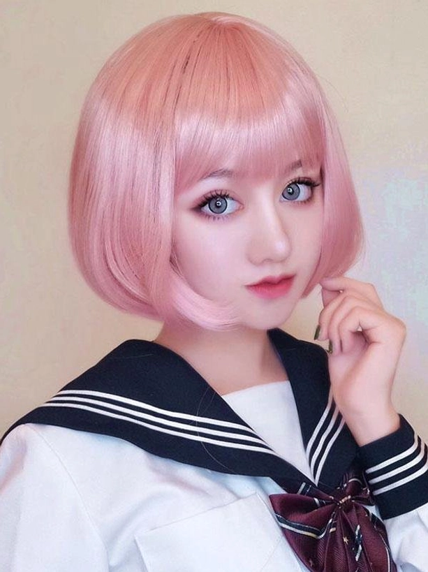 Pink lolita short bob wig with straight blunt bangs neat hairstyle close-up frontal view on model wearing sailor school uniform