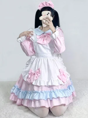 Pink maid Lolita dress full body front kneeling pose with twin-tails showing Peter Pan collar layered ruffled hem and large front bow