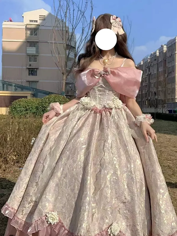Pink off-shoulder sweet lolita ball gown front three-quarter view featuring large pink off-shoulder bow, corset waist, jacquard fabric, and ruffled skirt trim with flower hairpin accessory
