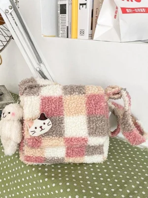 Pink plaid fleece Sweet Lolita crossbody bag flat lay display with cat badge and teddy bear pendant charm on polka dot background