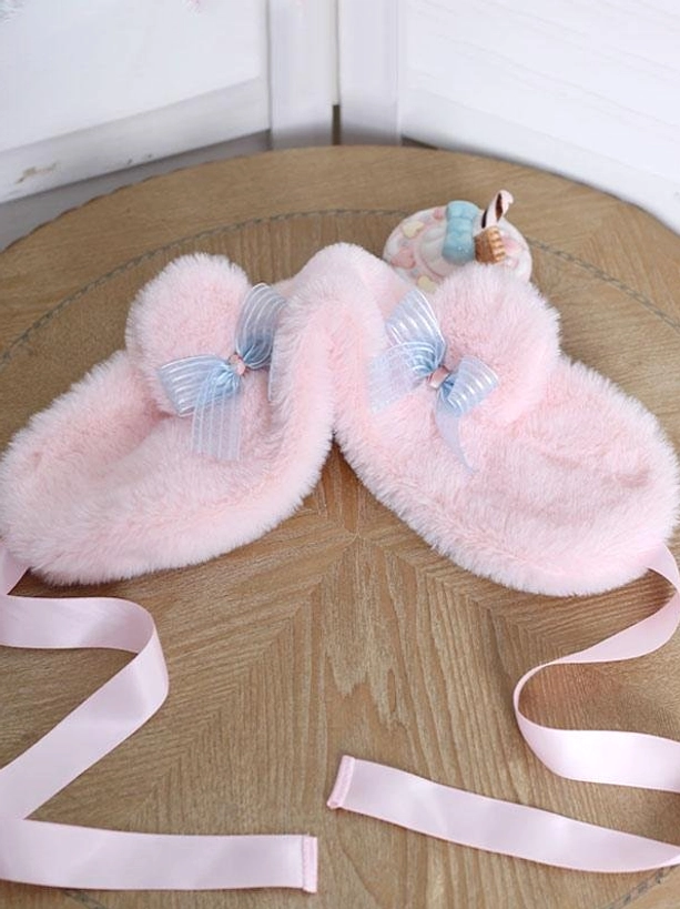Pair of pink plush bear ear lolita accessories with blue striped bows and pink tie straps displayed flat lay on wooden table - sweet lolita headdress detail shot