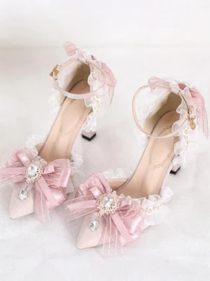 Front oblique view of pink Lolita high heel sandals featuring pointed toe, stiletto heel, ruffled lace trim, and large rhinestone-adorned bow decoration on white background, ideal for Sweet Lolita fashion
