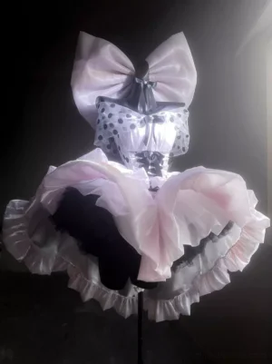 Pink polka dot ballet lolita dress backlit front view showing glowing silhouette large top bow and layered ruffled skirt