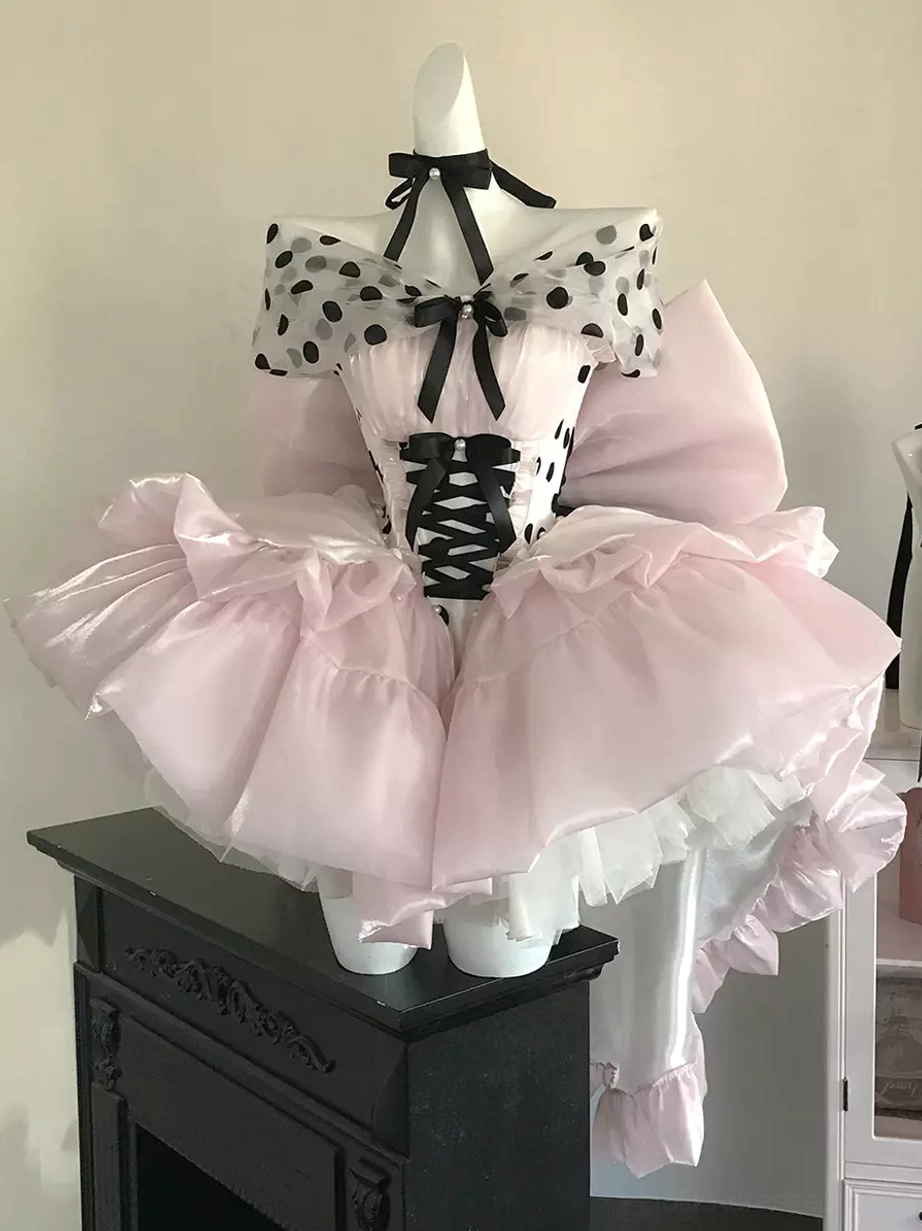 Pink polka dot ballet lolita dress side three-quarter view showing off-shoulder neckline high-low ruffled hemline fireplace setting