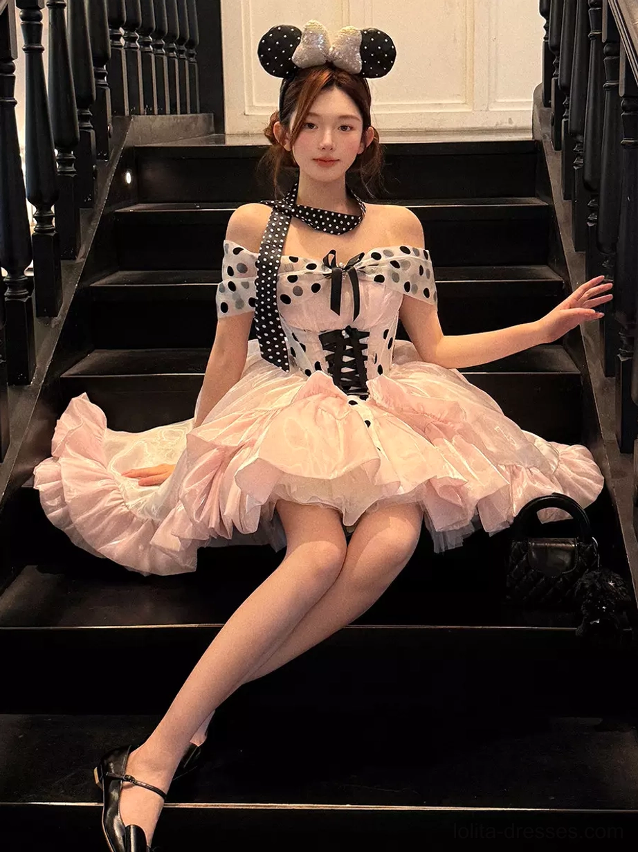Pink polka dot ballet lolita dress full body sitting view worn on female model with minnie ear headband and black heels indoor staircase