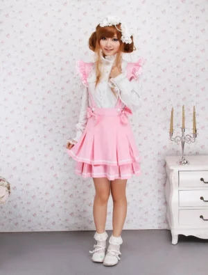 Sweet lolita pink polka dot multi-layer skirt front medium shot showing waist bow decorations and ruffled shoulder strap embellishments