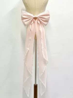 Pink rococo lolita detachable bow train tail accessory front view on mannequin with cascading mini bows and white lace trim
