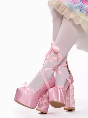 Sweet Lolita platform heels in pink satin with toe bow and rhinestone embellishments, crossed feet side view displaying rope ankle straps and geometric lattice heel design