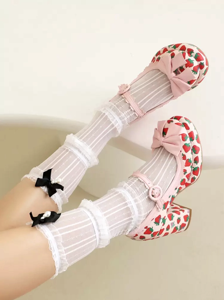 Pink strawberry lolita pumps with ankle strap buckle and pink front bow, overhead side view with ruffled sheer socks and black bows