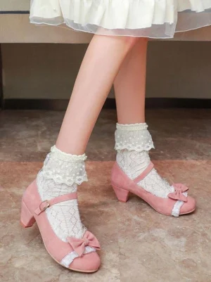 Pink suede Lolita Mary Jane shoes with bow ornament and ankle buckle strap, worn by model in white ruffle skirt, side view on marble floor showcasing round block heel