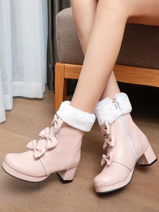Pink Sweet Lolita ankle boots with double bow ornaments and fuzzy fur cuff on model feet, side view showcasing chunky block heel and round toe design