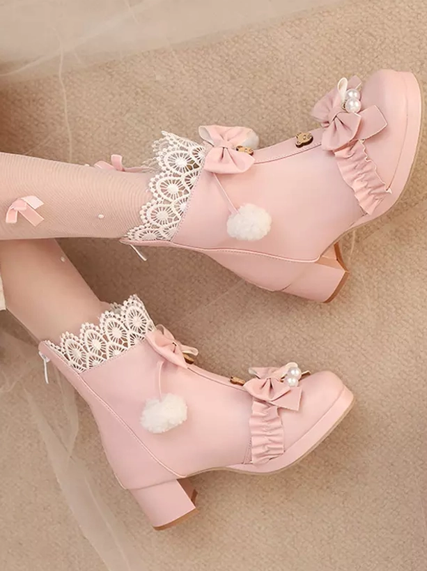 Pink Sweet Lolita ankle boots side standalone double shoe view in soft indoor setting, showing lace trim, bow decoration, pom-pom detail and chunky block heel