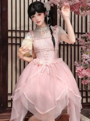 Pink sweet lolita midi dress with corset waist and layered tulle skirt shown in front squat perspective with cherry blossom background