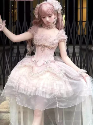 Pink sweet lolita corset dress with off-shoulder puff sleeves and layered tulle skirt, three-quarter front view on model at iron gate background