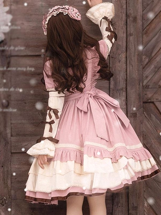 Pink sweet lolita OP dress back view showing waist sash bow layered ruffled skirt and lace-trimmed detachable sleeves