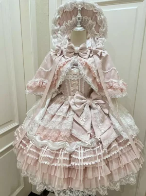 Pink sweet lolita dress set with cape front flat lay view showing tiered ruffled skirt and satin bows