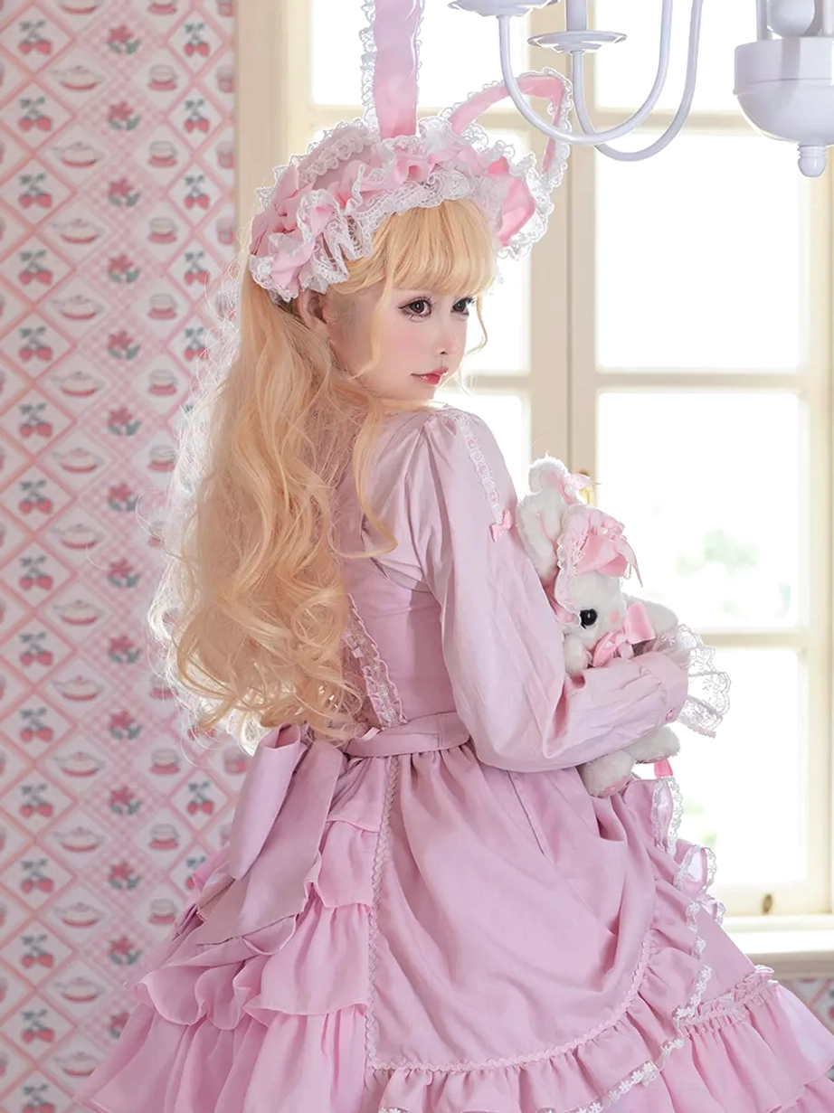Pink Sweet Lolita dress rear full-body view showing long ruffled back skirt with layered details near window