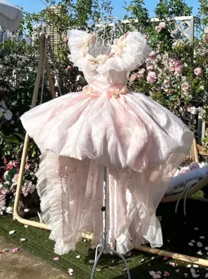 Pink sweet lolita fairy dress with off-shoulder ruffled neckline and layered ruffled train, full front view in garden setting with roses and urban backdrop