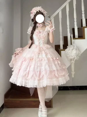 Pink sweet Lolita fairy dress front view with layered tulle ruffles and bow details on model wearing white platform shoes and matching accessories
