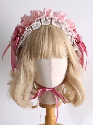 Pink sweet lolita headdress front view with two-tone ruffled lace design, dark pink side bows with streamers, worn on mannequin with blonde curly wig - elegant lolita accessory