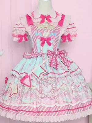 Pink sweet lolita JSK dress front view on mannequin featuring cartoon prints, ruffle bow decorations, and pastel pink aesthetic