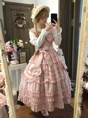Pink sweet lolita jumper skirt side angle view layered ruffled skirt waist bow white blouse twin braids