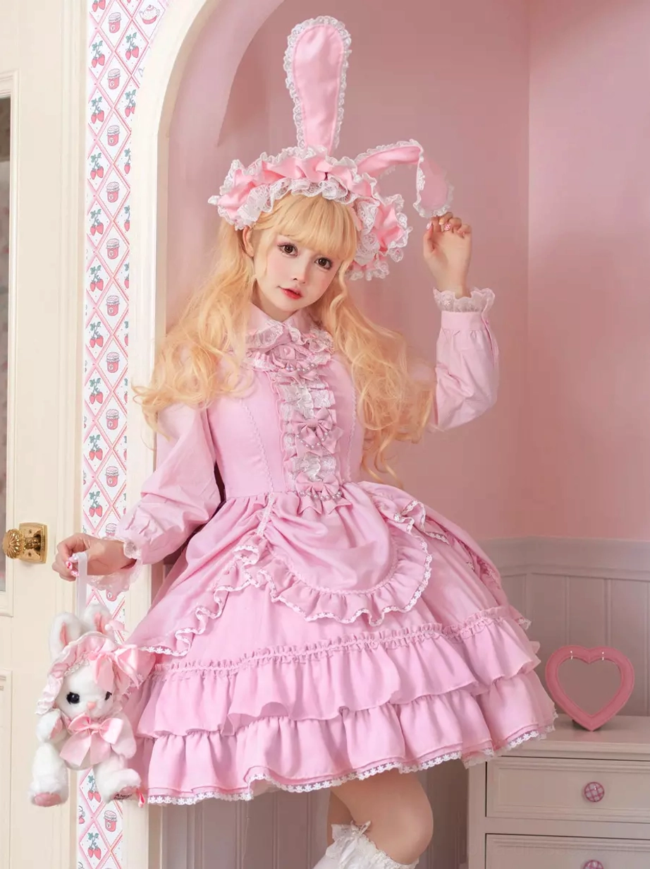 Pink Sweet Lolita dress full-body front view with ruffled lace trim, tiered pink skirt, model wearing bunny ear headband