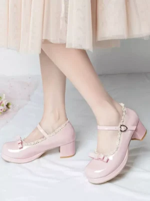 Pink patent leather sweet lolita mary jane pumps with heart-shaped ankle buckle and ruffled collar worn with light pink midi skirt front low-angle view