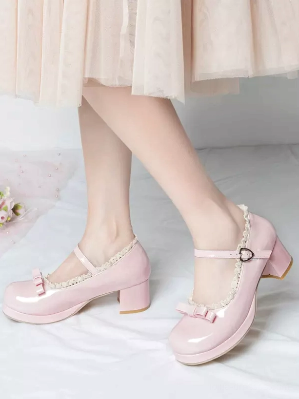 Pink patent leather sweet lolita mary jane pumps with heart-shaped ankle buckle and ruffled collar worn with light pink midi skirt front low-angle view