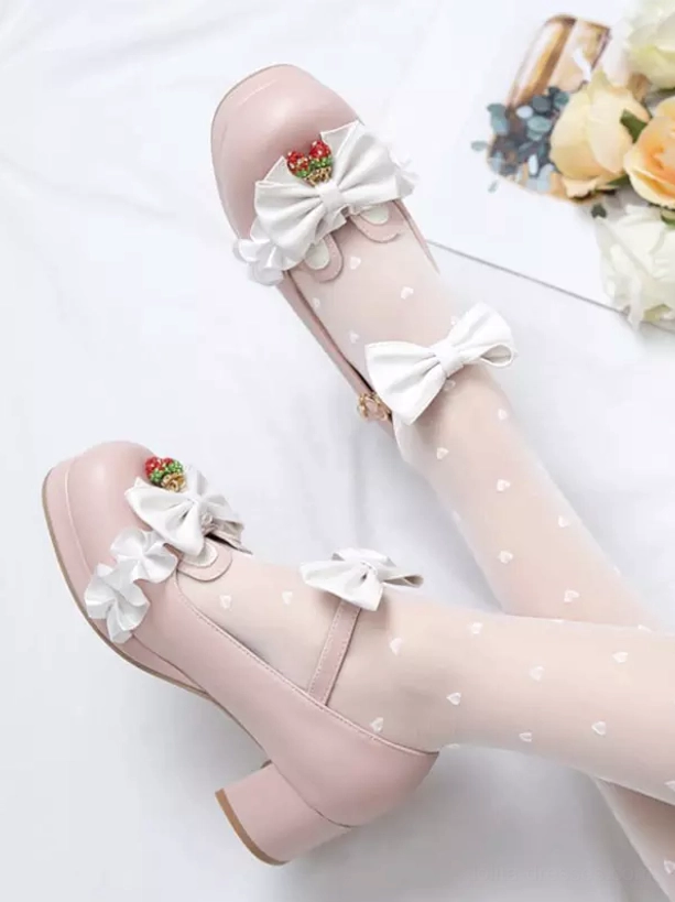Pink Sweet Lolita Mary Jane pumps on-foot top-down angle showing white bows, strawberry charms, chunky block heel paired with heart-patterned sheer stockings