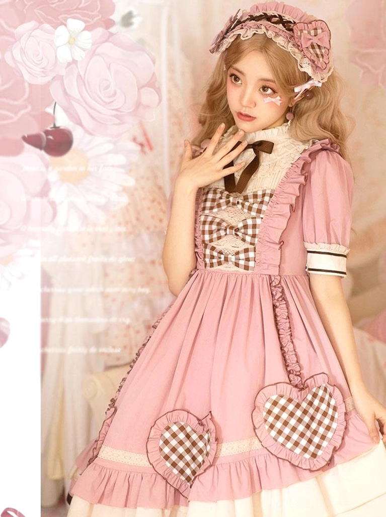 Pink sweet lolita dress with matching hair bonnet and heart-shaped gingham chest panel three-quarter front angle