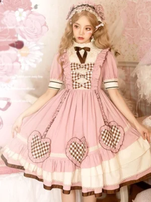 Pink sweet lolita one-piece OP dress with gingham heart patches and striped short sleeves front full-body view on blonde model
