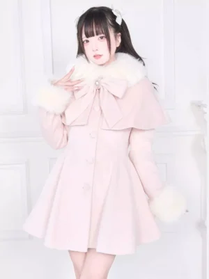 Front upper view of pink sweet lolita overcoat with white faux fur trim and large decorative front bow on female model in studio