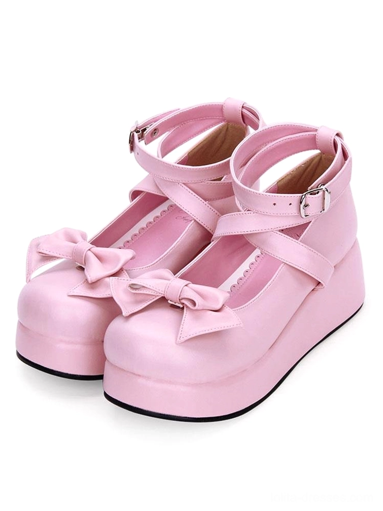 Pink Sweet Lolita platform pumps with soft pink leather finish, front bow embellishment, and crisscross ankle straps three-quarter side front view on white background