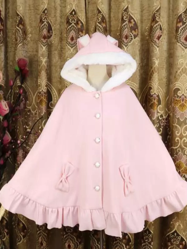 Pink Sweet Lolita poncho coat full front view with furry hood, pearl buttons, ruffled hem and bow pocket decorations on floral curtain background