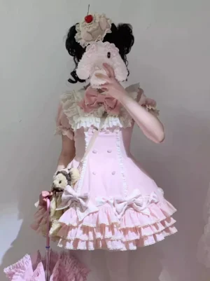 Pink sweet lolita dress with prominent front bow and tiered ruffle skirt, shown in half-front angle with model holding plush toy and small doll accessory