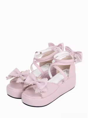 Pink sweet lolita platform sandals with dual bows front oblique top view showing scalloped lace trim and ankle wrap straps on white background