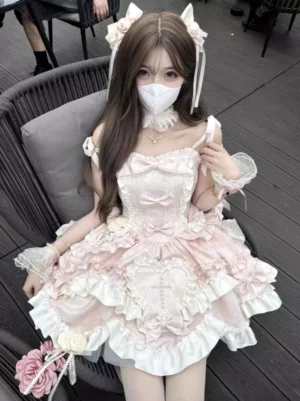 Pink sweet lolita sleeveless dress with tiered ruffles heart appliques and lace-up bodice front view outdoor