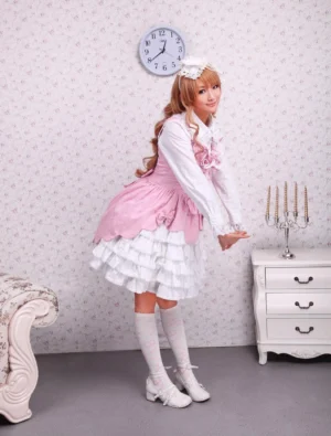 Sweet lolita jumper skirt side profile view showing layered tiered ruffled white underskirt, pink bodice, and waist bowknot decoration on model