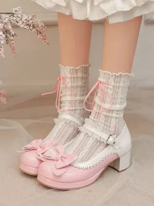 Pink and white sweet Lolita Mary Jane chunky heel pumps front view with large pink bow decoration, patent leather finish, worn with frilly white lace socks and ruffled skirt