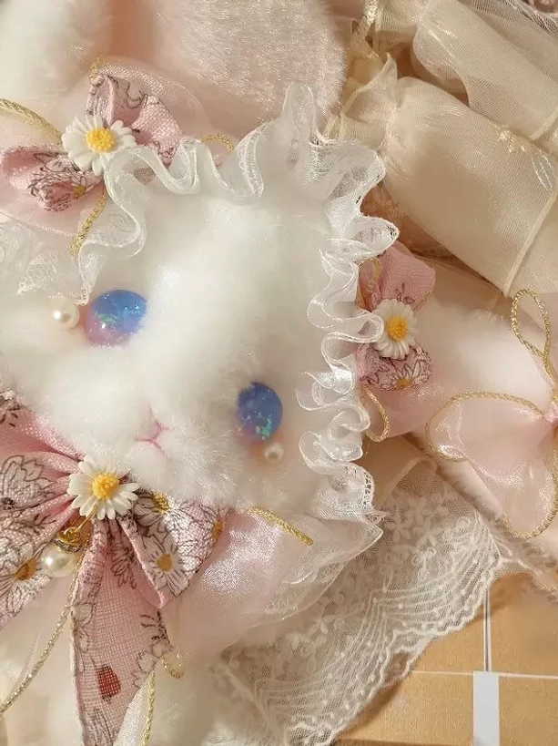 Plush bunny lolita accessory bag highlighting ruffles, bows, and glass eyes characteristics defining sweet lolita substyle within fashion community